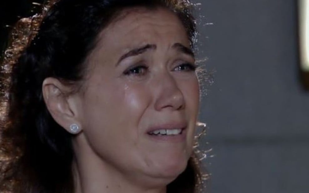 A atriz Lilia Cabral caracterizada como Griselda da Fina Estampa, personagem está de camiseta branca e está chorando