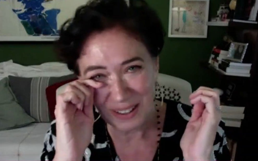 Lilia Cabral secando a lágrima do olho direito em vídeo chamada com Ana Maria Braga