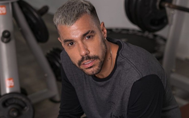 Imagem de Lipe Ribeiro de roupa cinza em uma academia