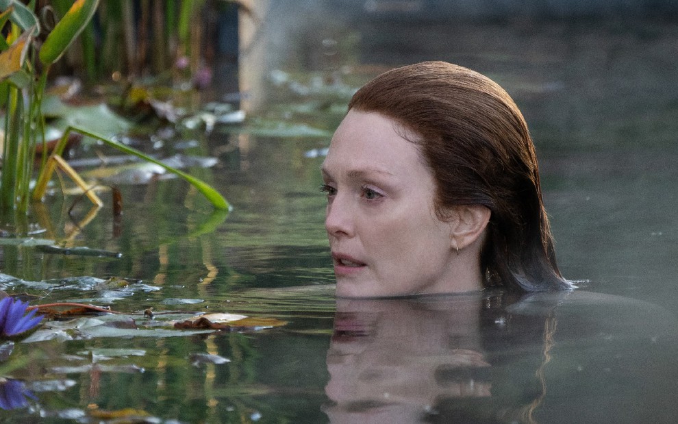 Lisey Landon (Julianne Moore) mergulhada até a cabeça em um lago olhando para as plantas