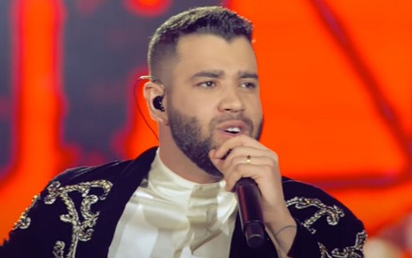 O sertanejo Gusttavo Lima segura o microfone e canta em show disponível no YouTube
