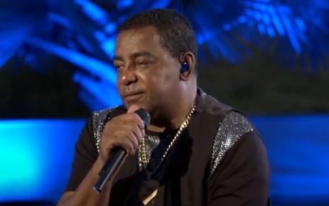 O cantor Luiz Carlos com o microfone na mão em live do Raça Negra