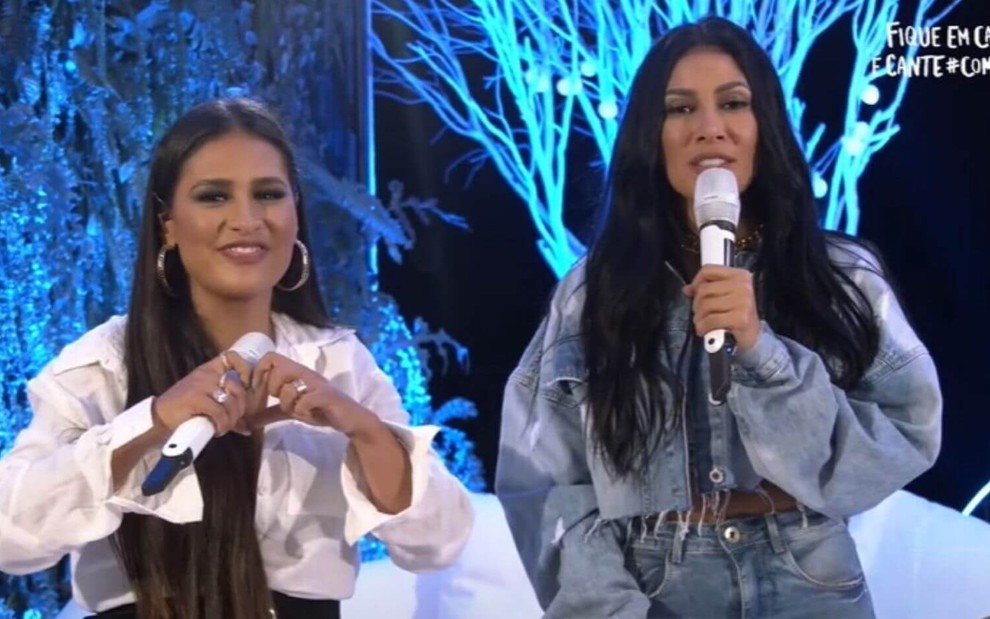 Simone faz um sinal de coração com as mãos ao lado de Simaria em live transmitida no YouTube
