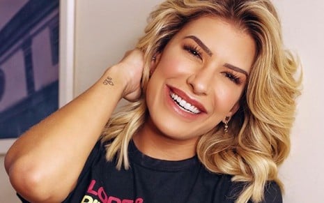 A cantora e bailarina Lorena Improta sorri e mostra tatuagem perto do pulso, em foto postada no Instagram