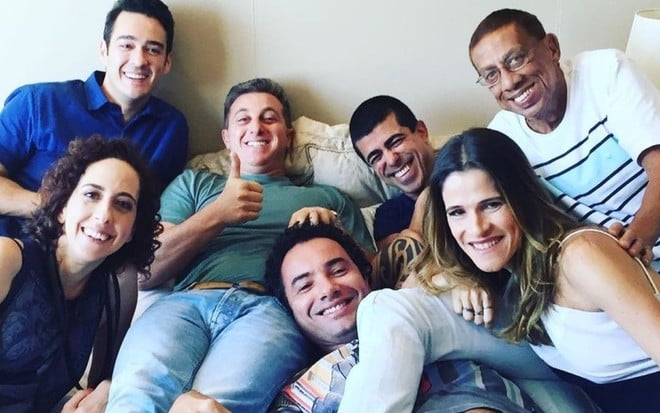 Luciano Huck ao lado de famosos com Marcius Melhem em foto descontraída no sofá