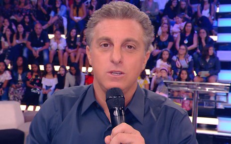 Luciano Huck de camisa azul escuro apresentando o Caldeirão, da Globo