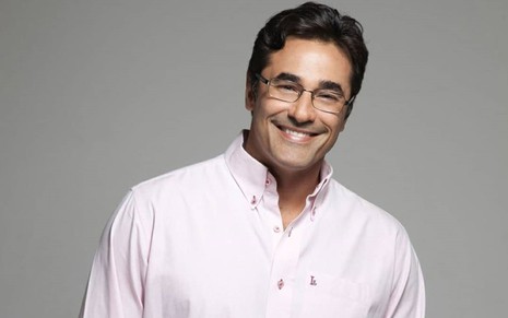 Luciano Szafir sorrindo, de óculos, usando uma camisa rosa