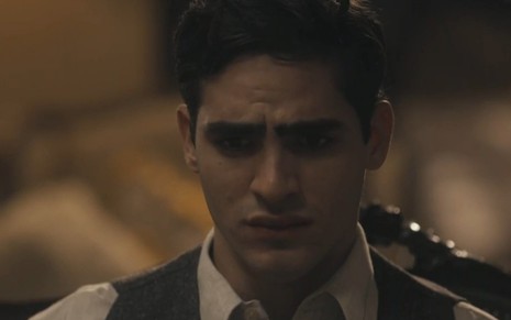 O ator Jhona Burjack com expressão triste e usando roupas de época em cena como Lúcio de Éramos Seis