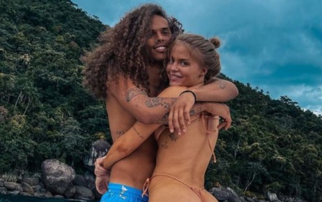 Vitão e Luísa Sonza olham para a câmera abraçados enquanto curtem passeio de barco