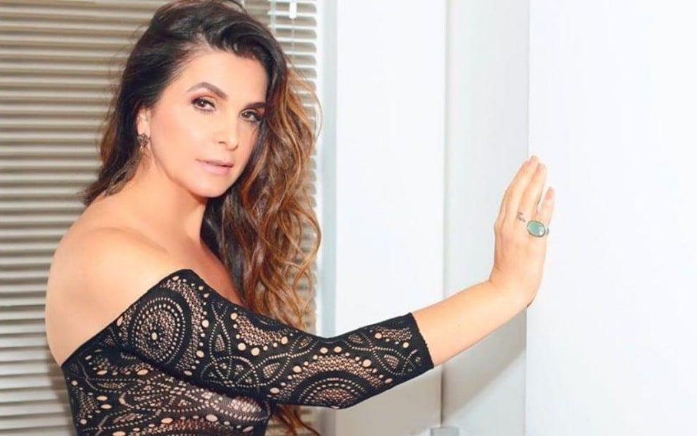 Imagem de Luiza Ambiel com o cabelo solto, usando uma blusa preta de manga com renda