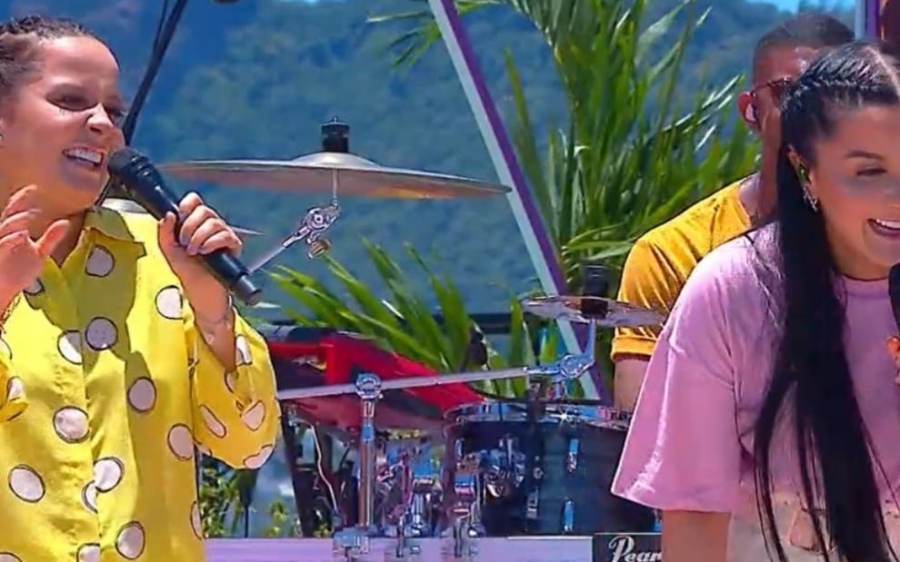 Maiara de camisa amarela e Maraisa de camiseta roxa dão risada no cenário do SóTocaTop Verão deste sábado (29)
