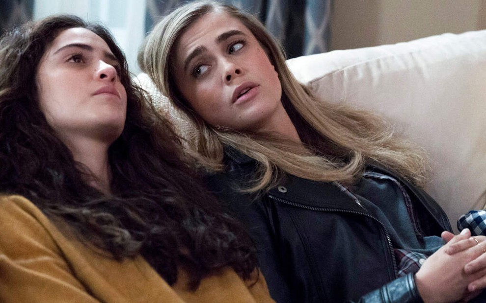 Esparramadas em um sofá, as atrizes Luna Blaise e Melissa Roxburgh expressam cansaço em cena da série Manifest