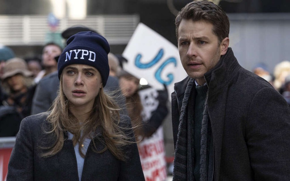 Melissa Roxburgh com um gorro da polícia de Nova York e Josh Dallas veste um casaco na série Manifest