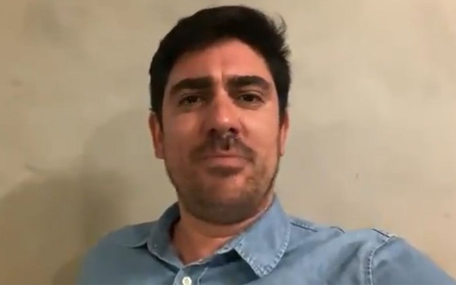 Imagem de Marcelo Adnet com camisa azul enquanto imita Jair Bolsonaro