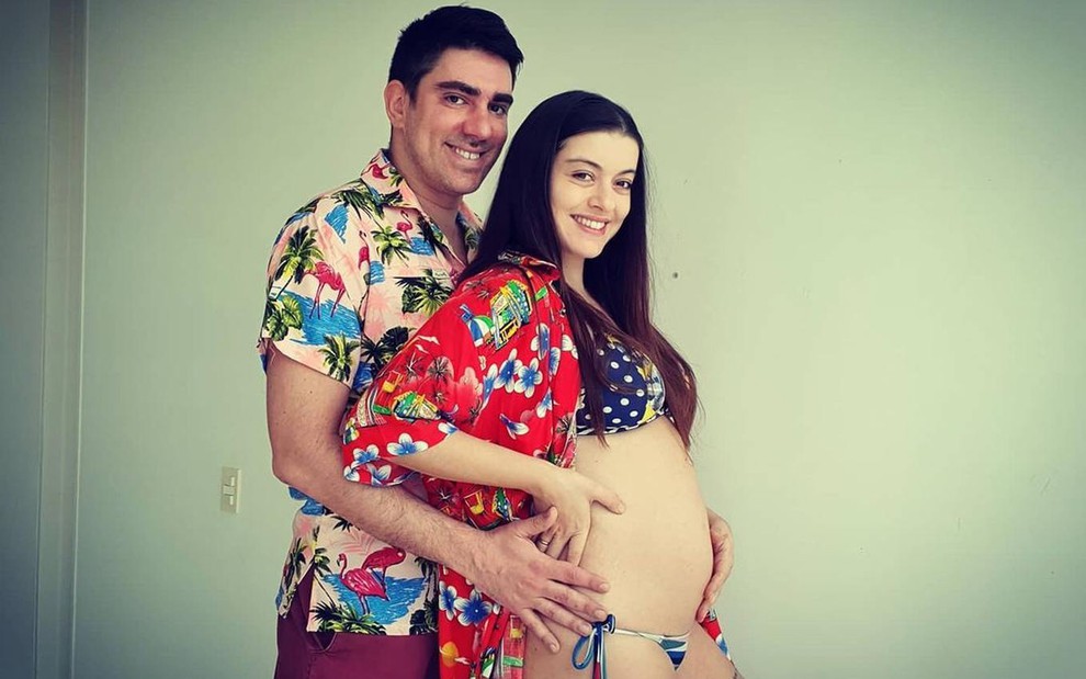 Marcelo Adnet abraçando Patrícia Cardoso com a mão na barriga de grávida