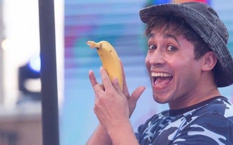 Marcelo Beny, intérprete do personagem Bananinha, brinca com uma banana enquanto sorri