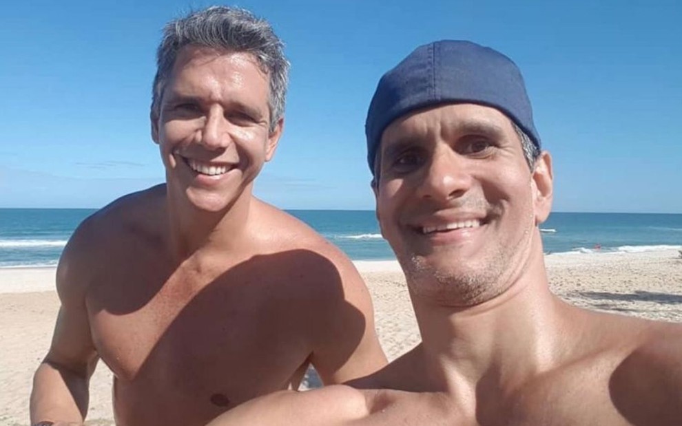 Imagem de Marcio Garcia e Marcello Machado, sem camisa, na praia