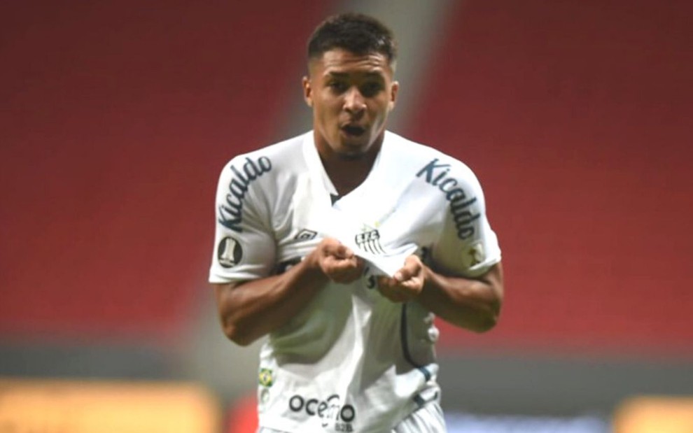 Marcos Leonardo comemora gol pelo Santos em frente à câmera mostrando o escudo do Santos