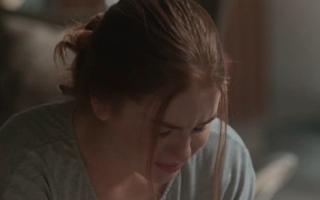 De cabelo preso em coque, Marina Ruy Barbosa (Eliza) chora com a cabeça levemente abaixada em cena de Totalmente Demais