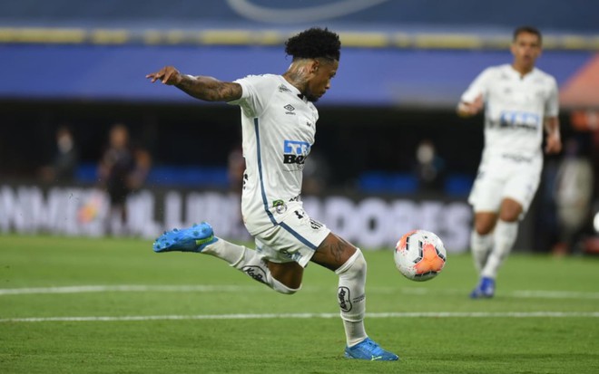 Marinho, jogador do Santos em campo em lance com a bola no ar, vestido com o uniforme do Santos na cor branca