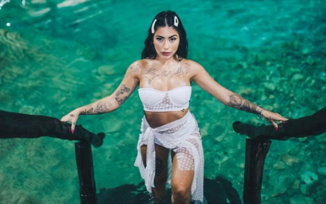 Mc Mirella saindo da água com biquíni branco