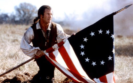 Mel Gibson segurando bandeira em cena de O Patriota