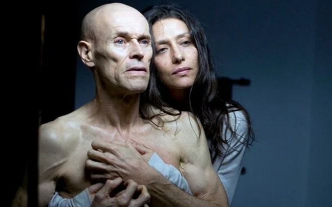 Careca e com aparência debilitada, Willem Dafoe é abraçado por Maria Fernanda Cândido em Meu Amigo Hindu (2015)