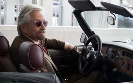 O ator Michael Douglas aparece caracterizado como Hank Pym, sentado em um carro olhando para longe