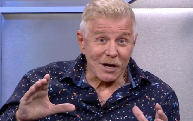 Imagem de Miguel Falabella com blusa azul e expressão facial empolgada em entrevista na CNN Brasil