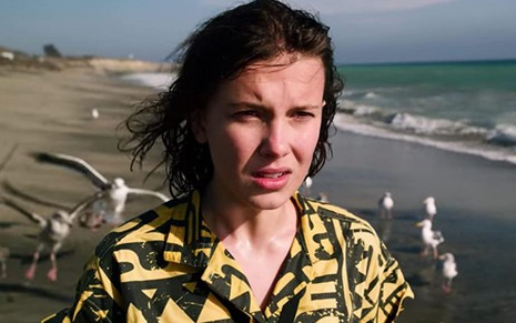 Millie Bobby Brown anda pela praia em cena da terceira temporada de Stranger Things