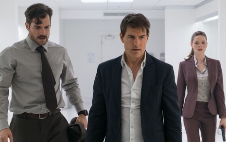 Henry Cavill (de cabeça baixa e bigode), Tom Cruise (sério) e Rebecca Ferguson (com arma na mão) em Missão: Impossível - Efeito Fallout (2018)