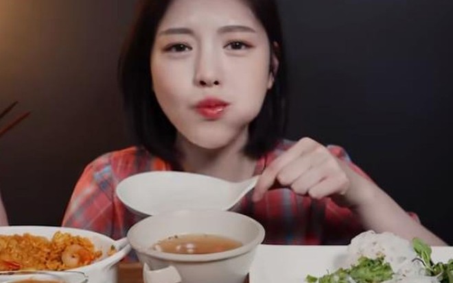 Moon BokHee atrás de uma mesa lotada de grandes porções de comida