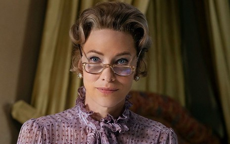 Com uma roupa lilas e óculos na ponta do nariz, Cate Blanchett aparece em cena da minissérie Mrs. America
