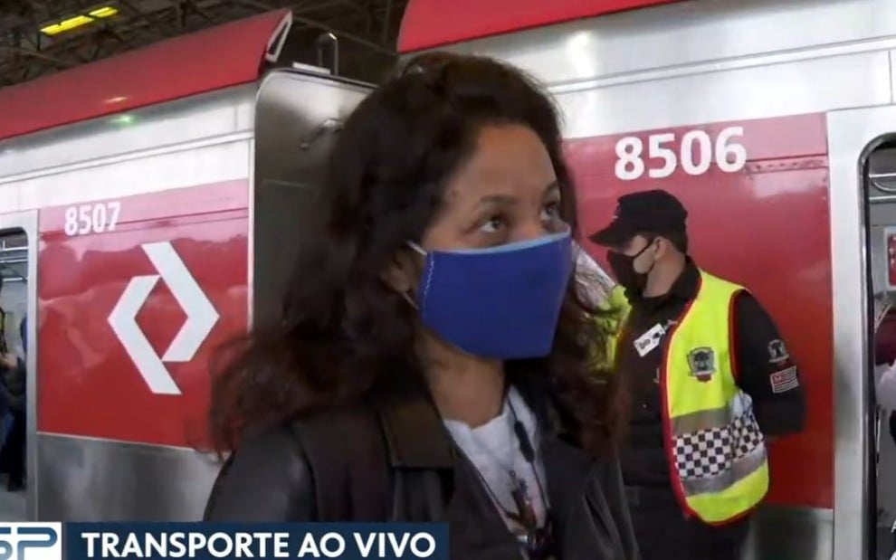 Entrevistada Jaque usando casaco preto e máscara de proteção azul