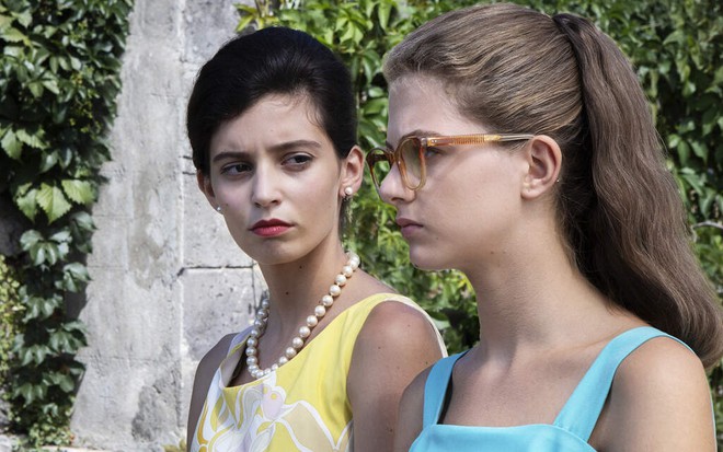 Com um vestdo amarelo e cabelo curto, Gaia Girace encara Margherita Mazzucco, com roupa azul, em My Brilliant Friend