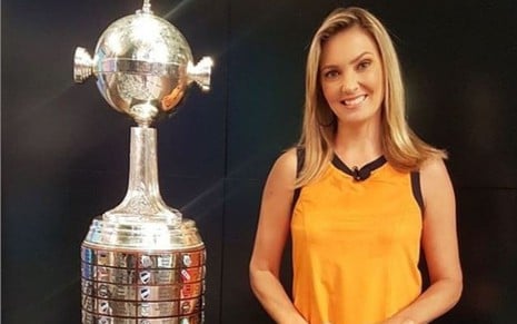 Nadine Basttos com a taça da Libertadores, de blusa amarela