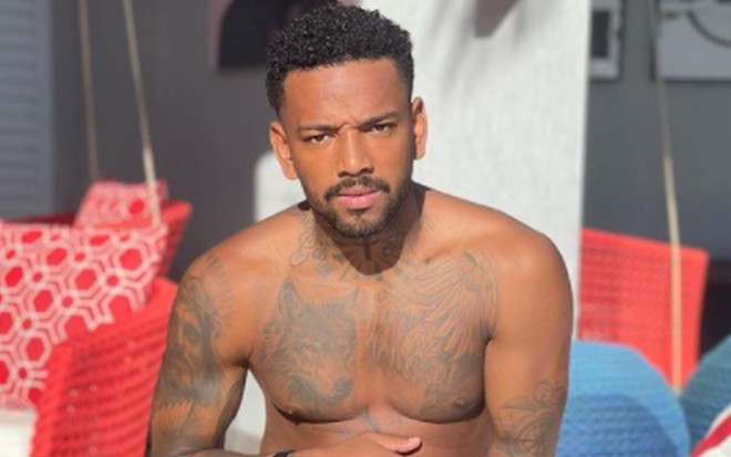 Nego do Borel sem camisa, com o corpo tatuado, de barba
