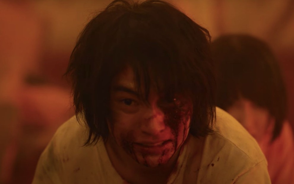 O personagem Arisu (Kento Yamazaki) olha com rosto machucado e ensanguentado na série Alice in Borderland