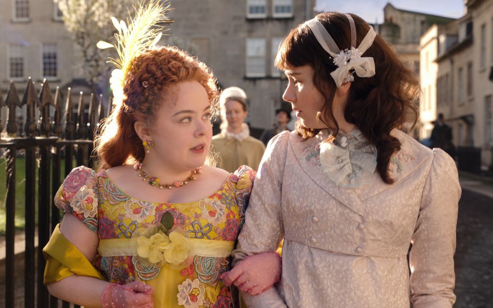 Penelope (Nicola Coughlan) e Eloise (Claudia Jessie) caminham em conversam em cena de Bridgerton