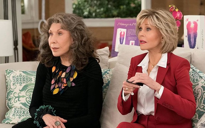 Lily Tomlin e Jane Fonda estão sentadas em sofá com expressão de susto em cena de Grace and Frankie