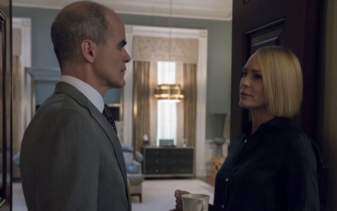 Michael Kelly e Robin Wright (com uma xícara na mão) se encaram em cena do drama House of Cards