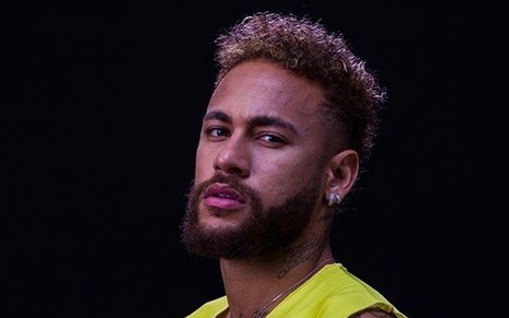 Neymar de camiseta amarela, barba e cabelo grande