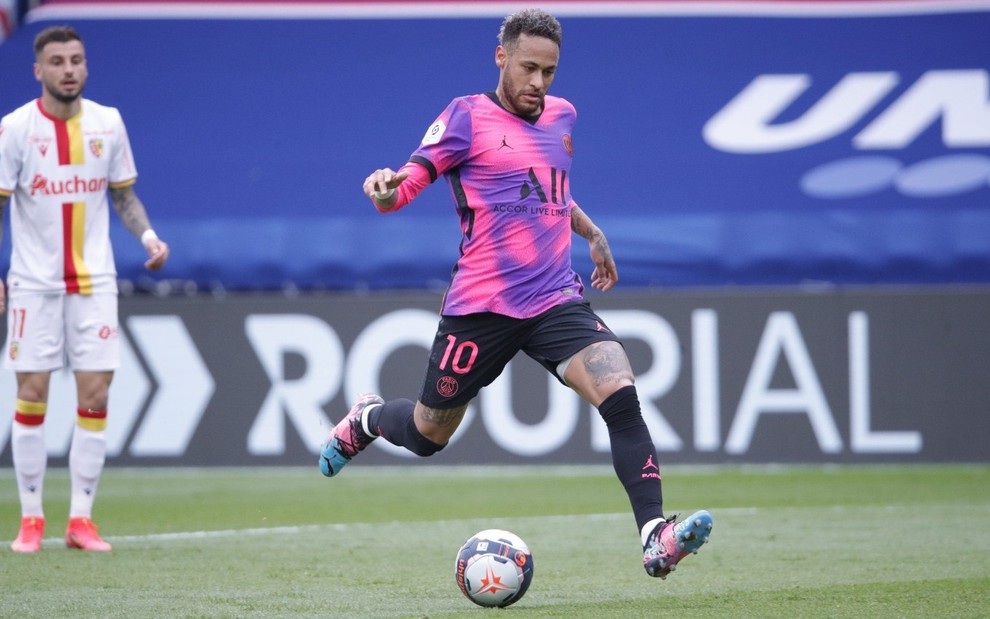 Neymar em jogo do PSG; ele está com camisa roxa e rosa do clube pronto para chutar a bola