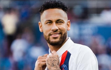 Em campo pelo PSG, Neymar coloca as duas mãos na altura do peito e sorri