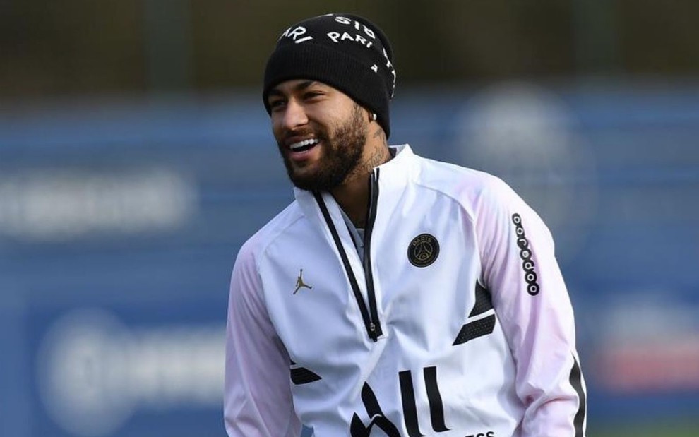 Neymar em treino do PSG, sorrindo, de toca, agasalho e luvas