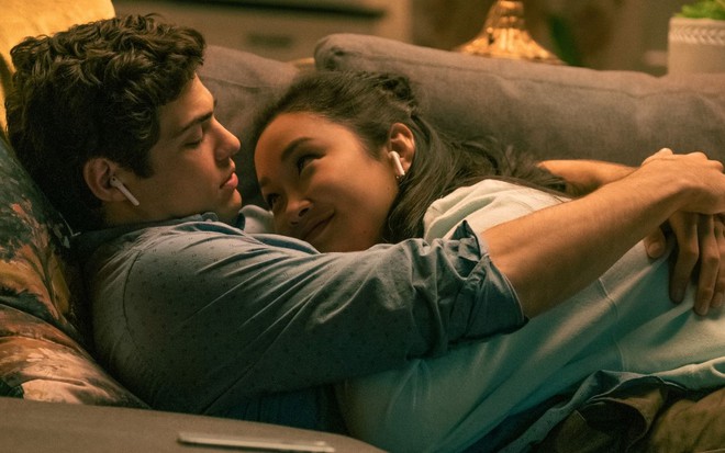 Peter (Noah Centineo) e Lara Jean (Lana Condor) deitados no sofá em cena de Para Todos os Garotos: Agora e Para Sempre