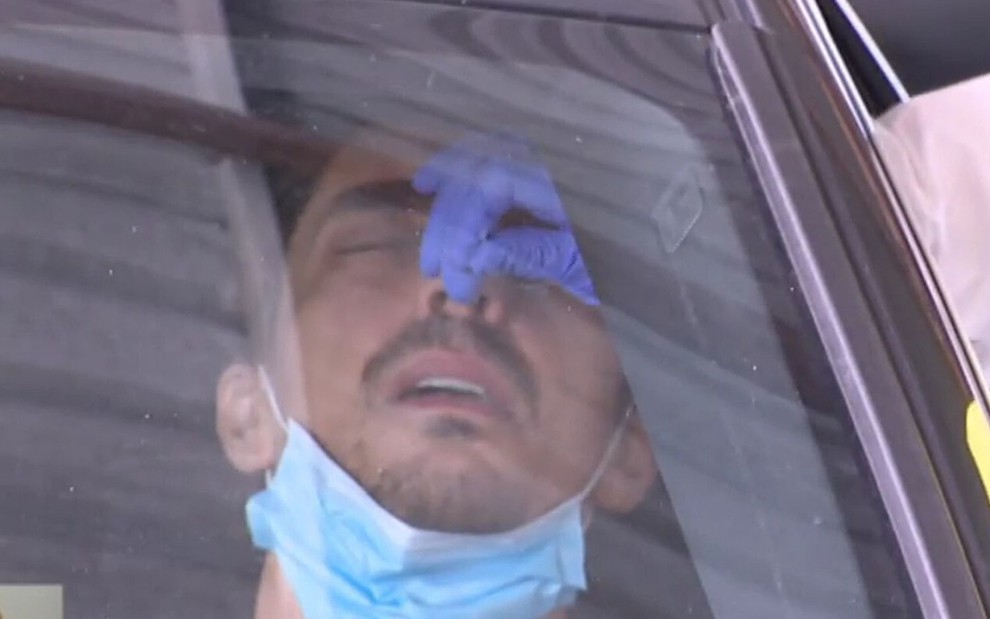 Dentro do carro, o ator português José Mata tem um cotonete colocado no nariz para teste de Covid-19