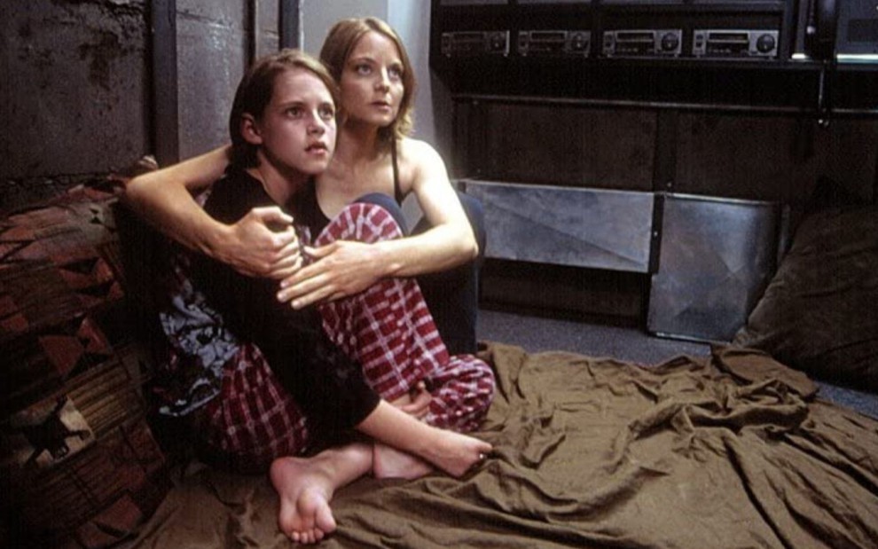 Kristen Stewart e Jodie Foster se abraçam sentadas no chão em cena do filme O Quarto do Pânico