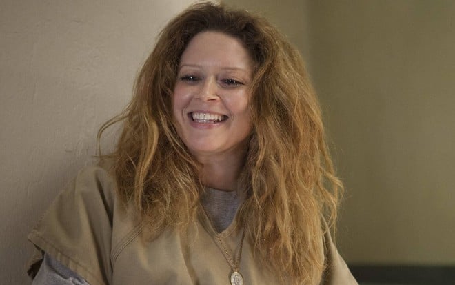 Sorridente e descabelada, Natasha Lyonne aparece com uma roupa de presidiária em Orange Is the New Black