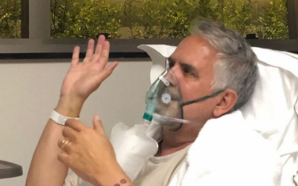 Orlando Morais, com material para auxílio para respiração, após receber alta da UTI em que estava internado com Covid-19